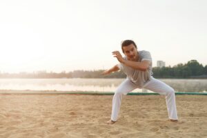 Athletic capoeira performer making movements on the beach